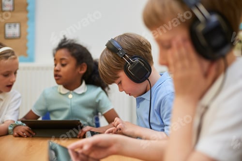 Preview: Kids engaged in interactive learning with tablets and headphones at school.