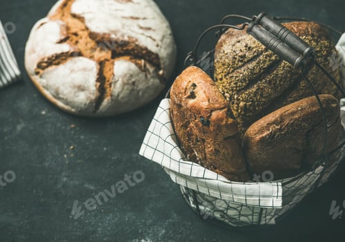 Preview: Various bread loaves over black background, copy space