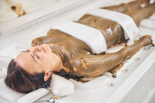 Preview: Gladsome woman during the whole body wrap treatment