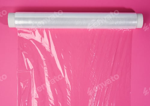 Preview: Roll of transparent cling film on pink background
