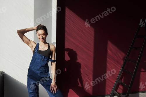 Preview: Cheerful mood. Young housewife decided to glue wallpaper in her new house in the room