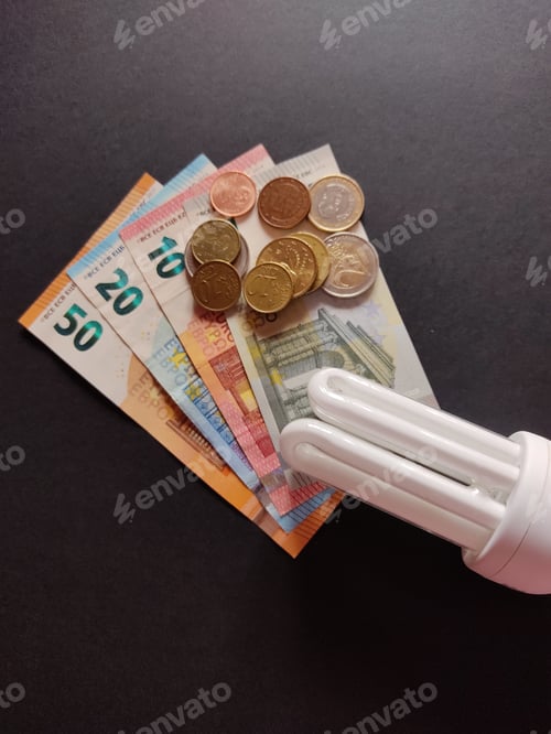 Preview: Closeup of compact fluorescent lamp on euro coins and banknotes