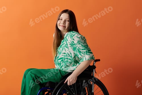 Preview: Enchanted woman in green dress embracing wheelchair
