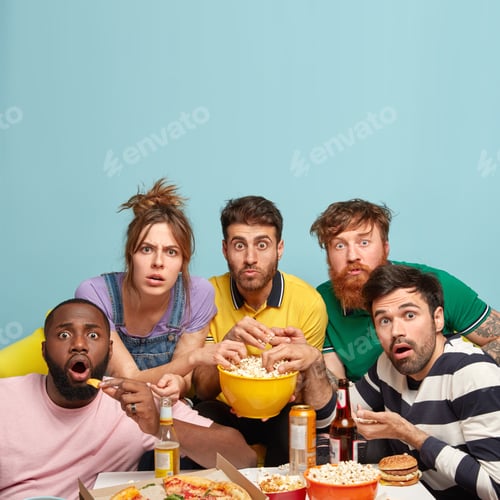 Preview: Vertical shot of shocked mixed race companions or fellows, watch terror movie with popcorn, have sca