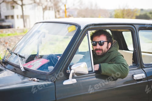 Preview: Portrait of mid adult man driving vintage car