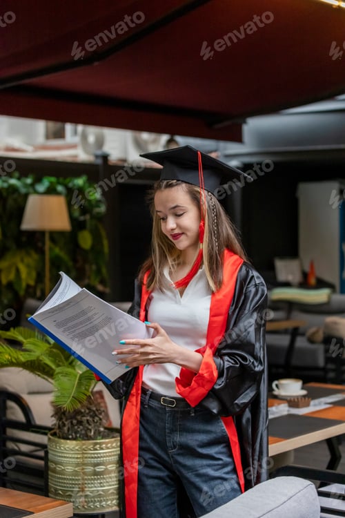 Preview: Vertical photo of young student holding notebook and looking at it