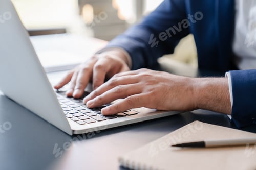 Preview: Cropped close up image of businessman`s hands typing working on laptop at home office.