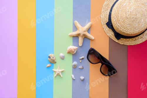 Preview: Beach accessories: glasses and hat with shells and sea stars on a colored background