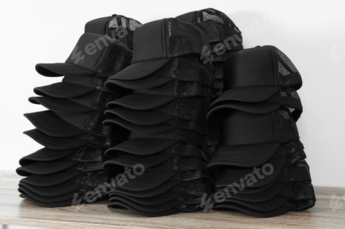 Preview: Many blank black caps on wooden table near light wall. Mock up for design