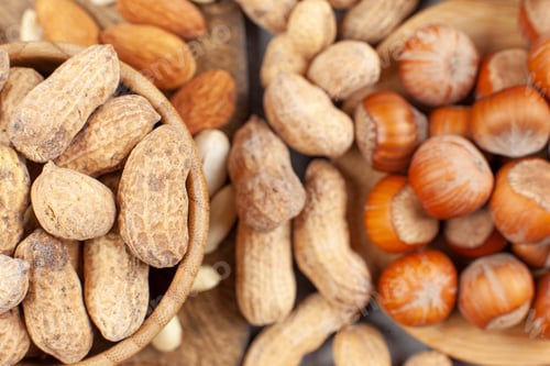 Preview: A heap of almonds, peanuts and hazelnuts in bowls and on wooden board