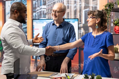 Preview: Senior citizens shaking hands with advisor after discussing retirement plans