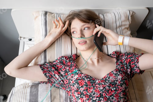 Preview: Brunette teenage girl speaking on mobile phone while resting
