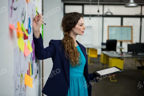 Preview: Female executive giving presentation while using digital tablet