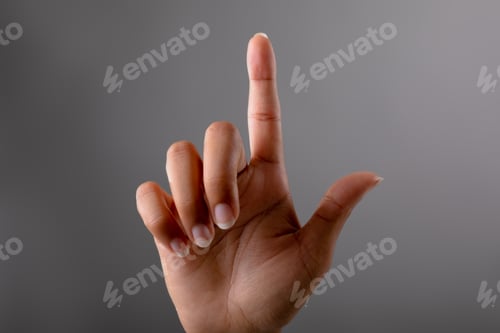 Preview: Close up of hand touching invisible screen against grey background