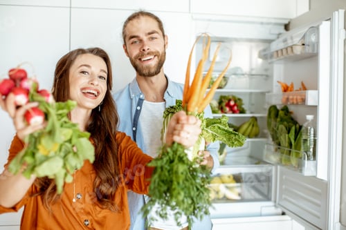Preview: Young couple with healthy food at the kitchen