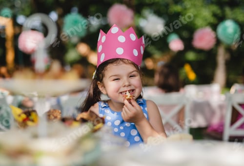 Preview: Cheeky small girl outdoors in garden in summer, eating snacks