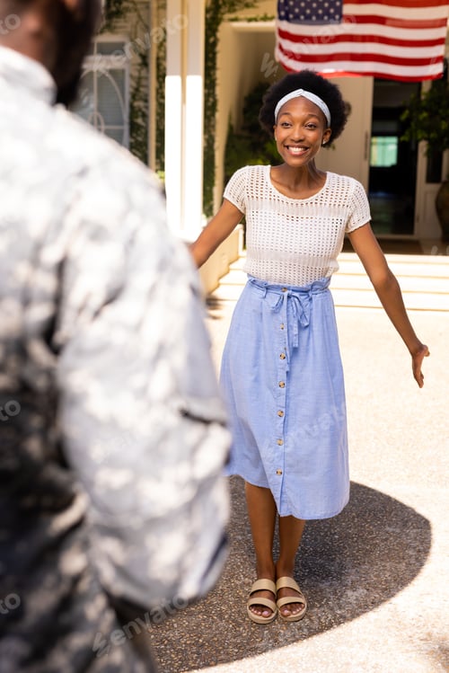 Preview: Happy african american woman excitedly looking at military husband after returning home from army