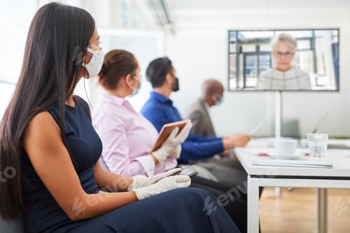 Preview: Business Team With Face Mask At Meeting With Video Conference On Monitor
