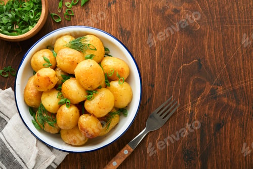 Preview: Boiled new or young potatoes with butter, fresh dill and onions in white bowl on dark old rustic woo