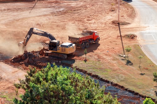 Preview: An Excavator digging up the ground and loading dirt into a dump truck