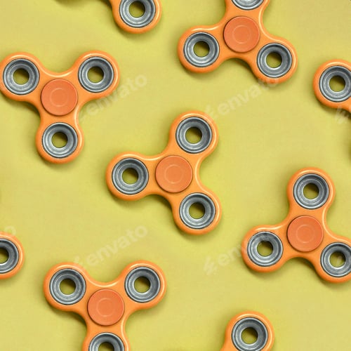 Preview: Many orange fidget spinners lies on texture background of fashion pastel orange color paper in