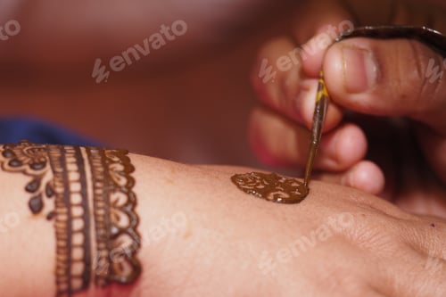 Preview: Applying intricate henna designs on a hand in celebration