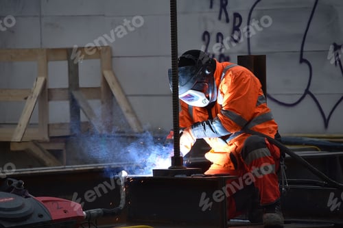 Preview: Man in a work suit and with a helmet, welding at the construction site of Vienna's metro