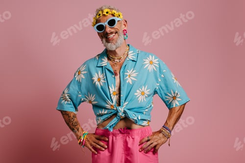 Preview: Bearded gay man in stylish shirt and floral wreath on head smiling against pink background