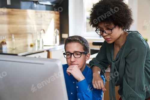 Preview: Two colleagues looking at computer monitor in office