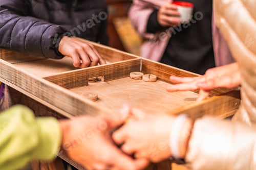 People Playing A Game On A Wooden Board