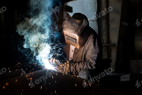 Preview: Closeup worker in a mask doing the welding in a workshop