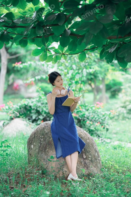 Preview: Young Woman Reading Book in Green Park