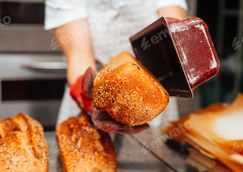 Preview: the baker takes out the finished baked bread from the molds