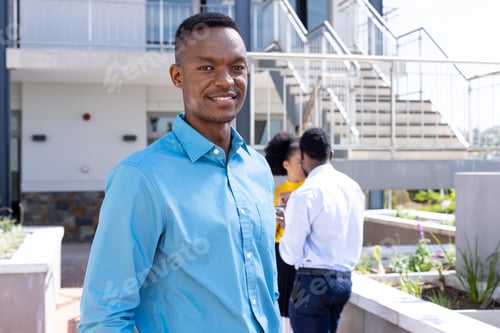 Preview: Portrait of happy african american businessman with diverse colleagues in background