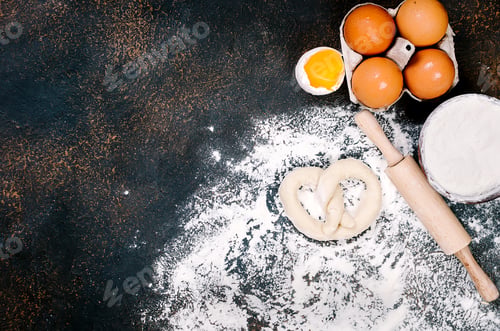 Preview: Raw yeast dough in bowl and ingredients, eggs, flour, ears of wheat on table, bakery concept,