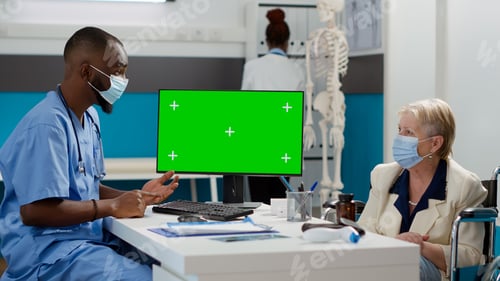 Preview: Nurse looking at greenscreen display with paralyzed patient