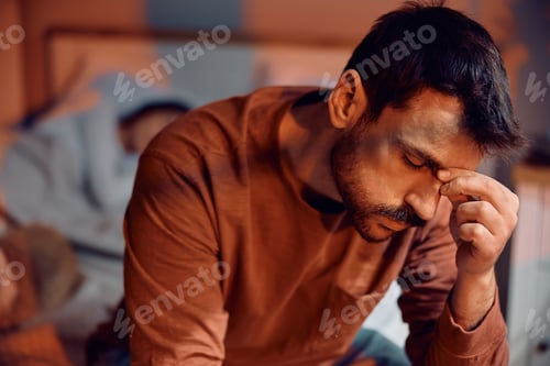 Preview: Worried man thinking of his problems in bedroom.