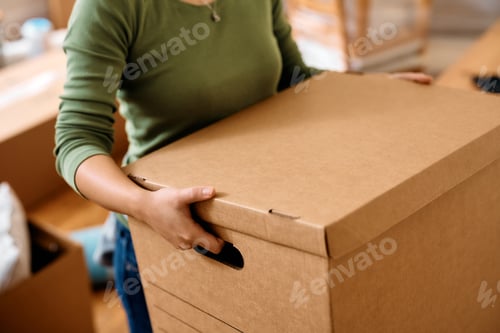 Preview: Close up of woman carrying box with her belongings while moving into new home.