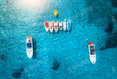 Preview: Aerial view of luxury yachts and boats on blue sea at sunrise