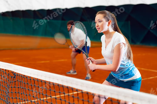 Preview: Pair of tennis players, man and woman waiting for service at indoor court