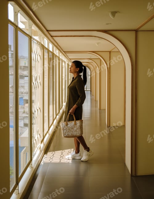 Preview: Asian women at the balcony of an art deco luxury hotel architecture from the 80s