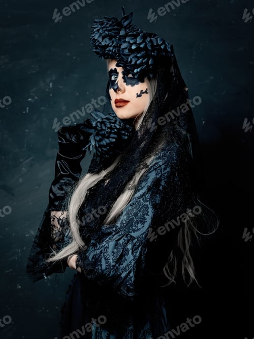 Preview: portrait of a girl in a witch costume with black flowers on a dark background.