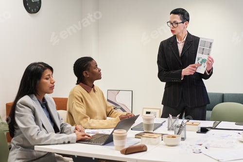 Preview: Middle Aged Caucasian Woman Presenting Report to Diverse Young Colleagues