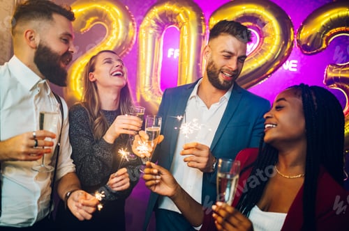 Preview: Multiracial friends celebrating new years eve with champagne and sparklers