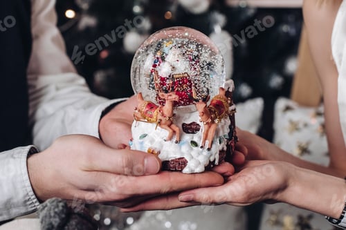 Preview: Close-up hands of couple male and female holding statuette of Santa Claus with deer