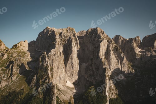 Preview: Rocky mountain tops with greenery and moss-covered cliffs