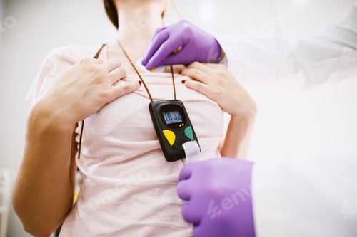 Preview: Close Up Of A Doctors Hands Putting Holter Monitor Device On Woman.