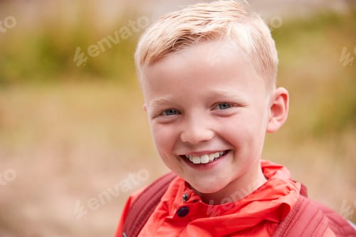 Preview: Portrait of pre-teen Caucasian boy outdoors, front view
