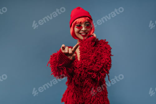 Preview: Lovely cool woman with modern sunglasses and short hair in cap and red fluffy long sleeve outfit sm
