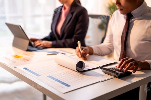 Preview: Two people are sitting at a desk with a white table